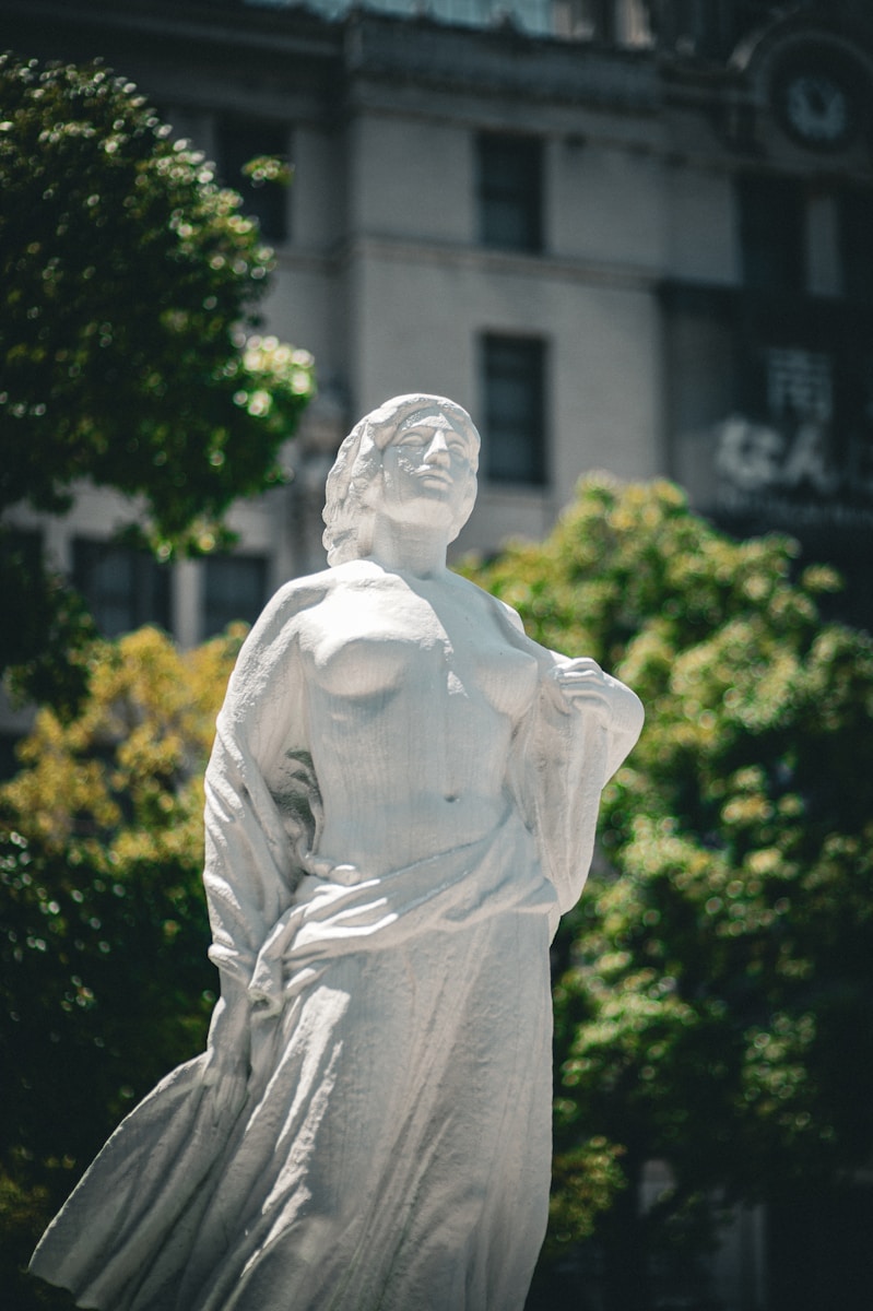 A statue of a woman in front of a building